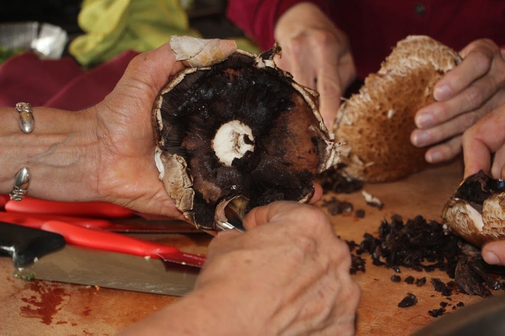 Removing the gills from the portobello mushrooms