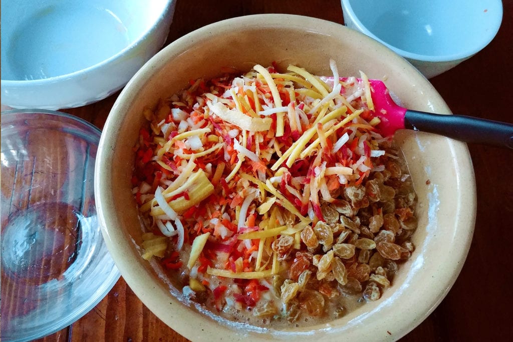 Folding shredded carrots and raisins into the batter for Strawberry Creek Inn's carrot cake muffins