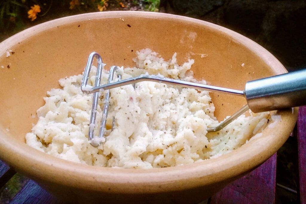 Mash the potatoes with the artichoke pesto