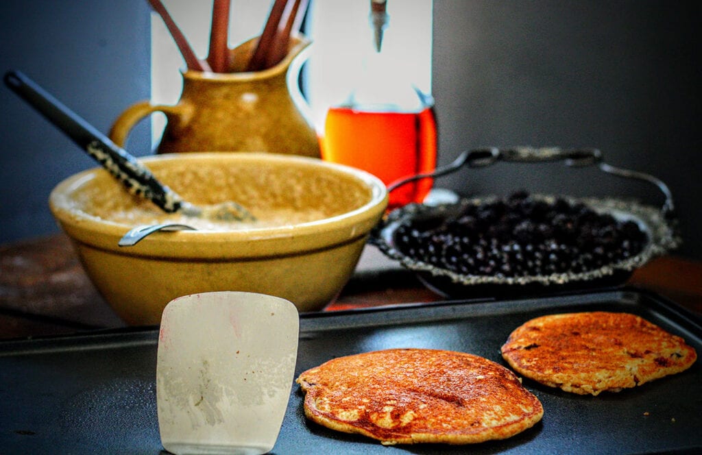 Scoop a half cup of batter onto a griddle or skillet for each pancake, top with huckleberries, then flip after bubbles form at the edges.