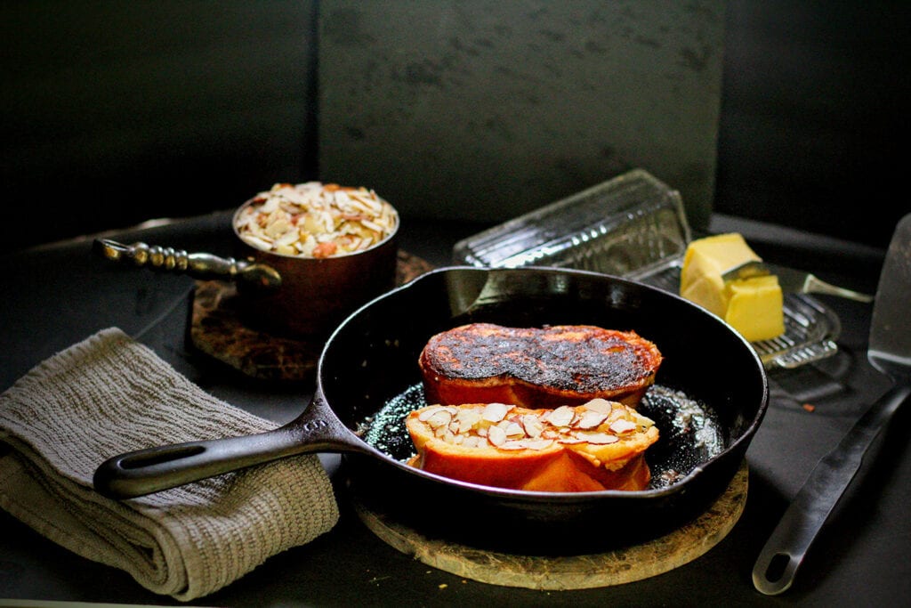 While one side of the bread is browning, press a layer of almonds into the uncooked side, then flip to brown that side and toast the almonds.