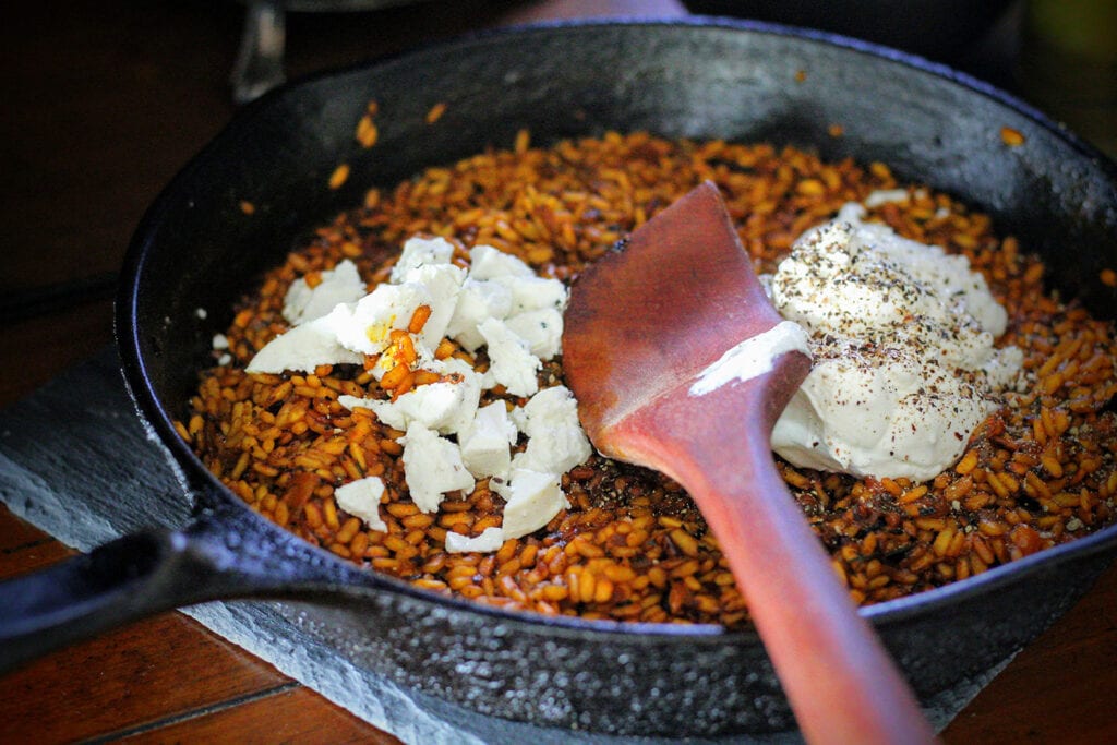 Stir in crème fraiche and half of goat cheese, then season heavily with black pepper.