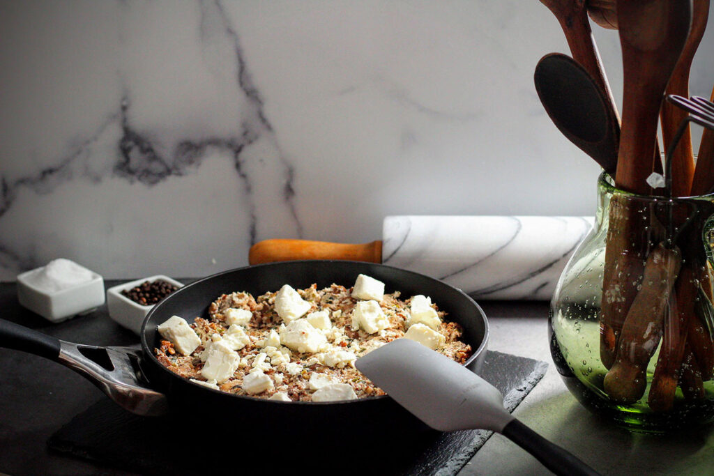 Sauteing shopped mushrooms and green onions and then stirring in the cheese and pecans