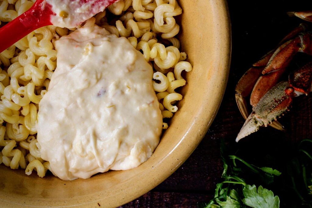 Stirring the cheese sauce into the cooked pasta