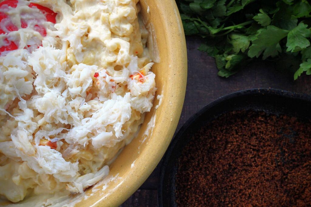 Folding crab meat into the pasta and cheese