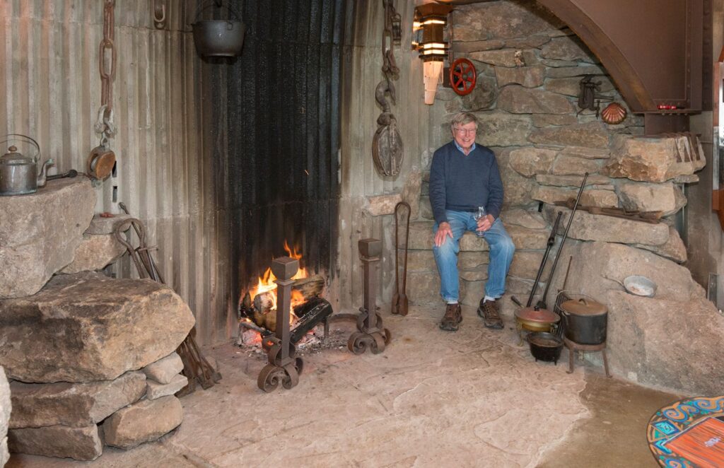 Owner Will Jackson in the sit-in fireplace at The Inn at Newport Ranch