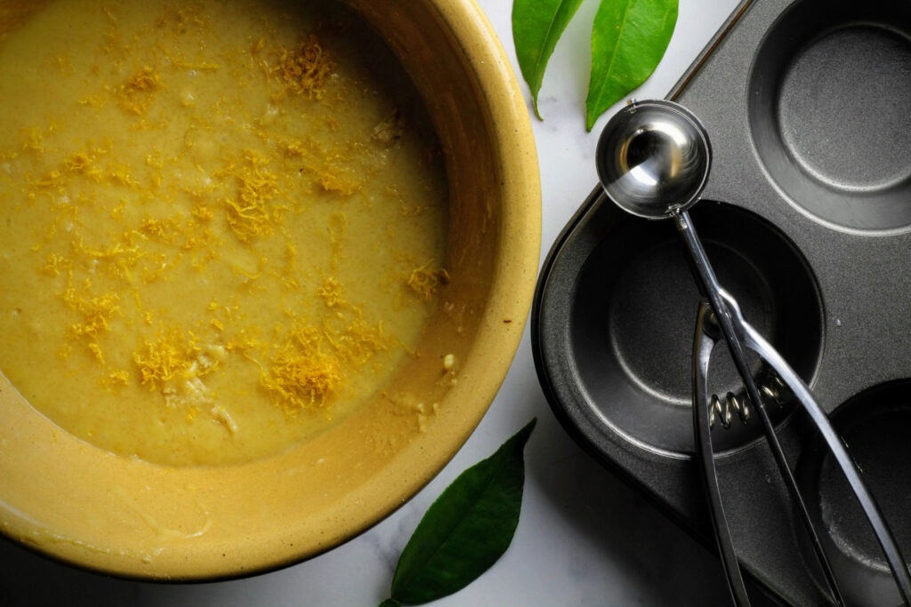 Sprinkle the zest on top of the batter before mixing it in, to prevent clumping.