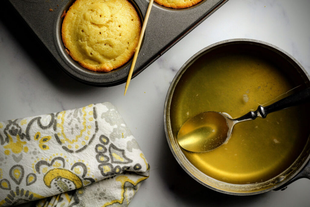 While the muffins are baking, simmer lemon juice and sugar to make a lemon syrup. Poke holes in the muffins.