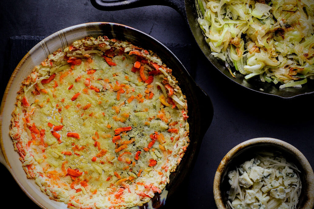 Pie dish lined with hash browns for quiche