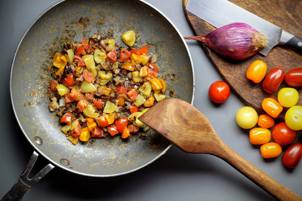 Sauté the shallots and tomatoes in olive oil until the shallots are translucent.