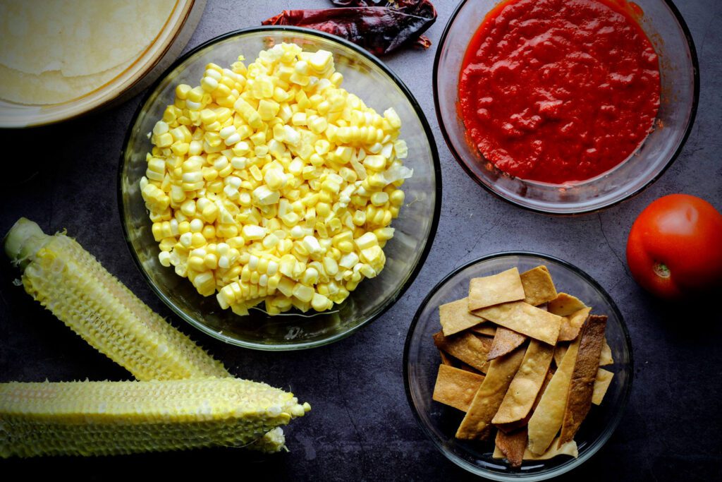 Cut corn from cobbs; make and set aside fried tortilla strips and chile-tomato puree.
