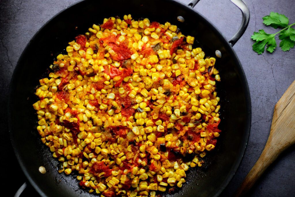 Toss corn with chopped vegetables and roast in the oven until caramelized.