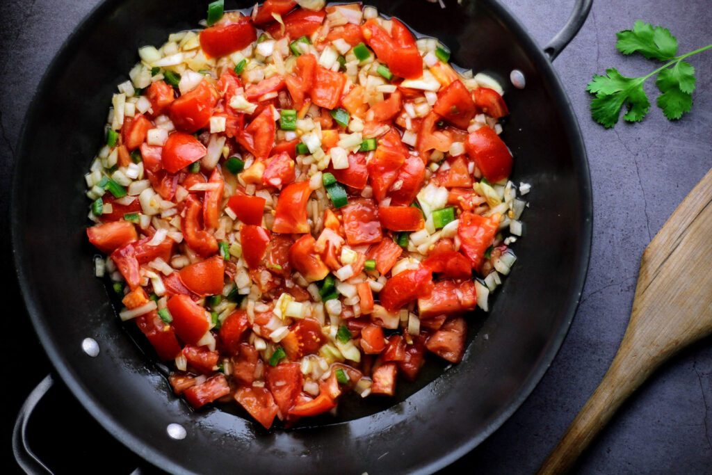 Chop tomatoes, onions, garlic, and jalapenos.