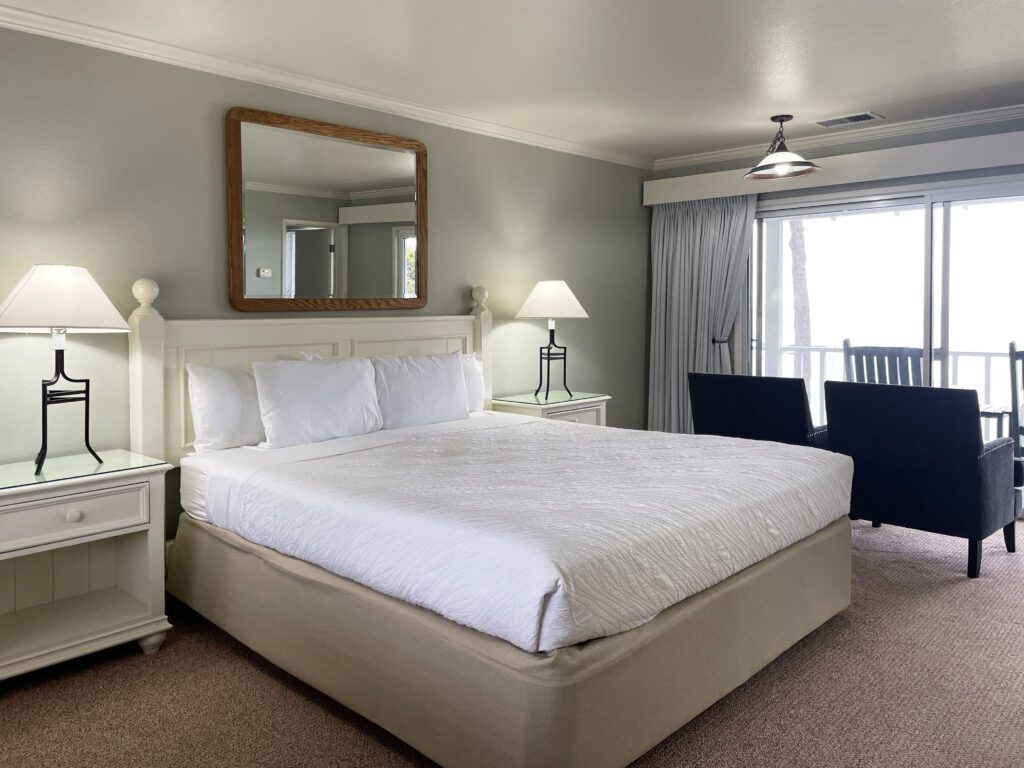 A traditional guest room at Little River Inn with sliding glass door that open to ocean views