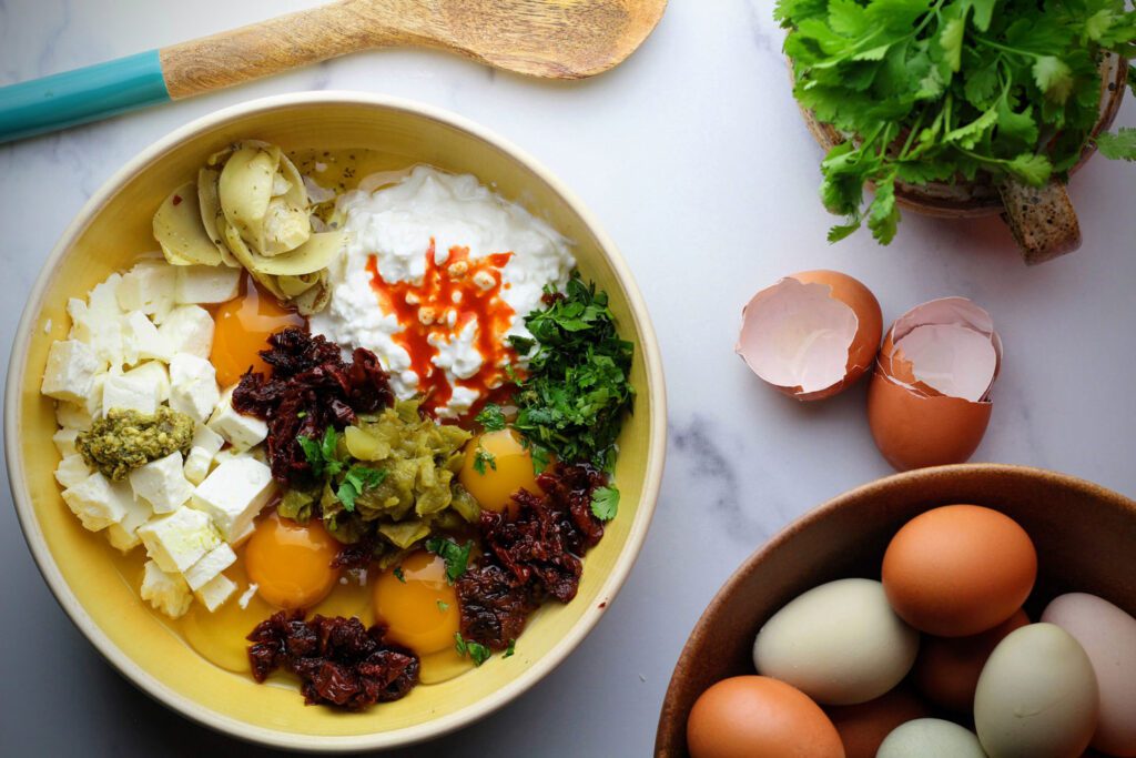 Combine eggs, cheese, vegetables, and seasonings in a bowl.