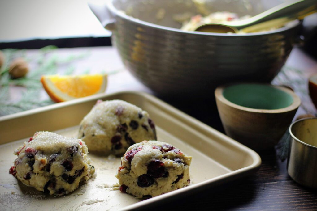 Scoop the scones onto a greased baking sheet, then brush with cream and sprinkle with sugar.