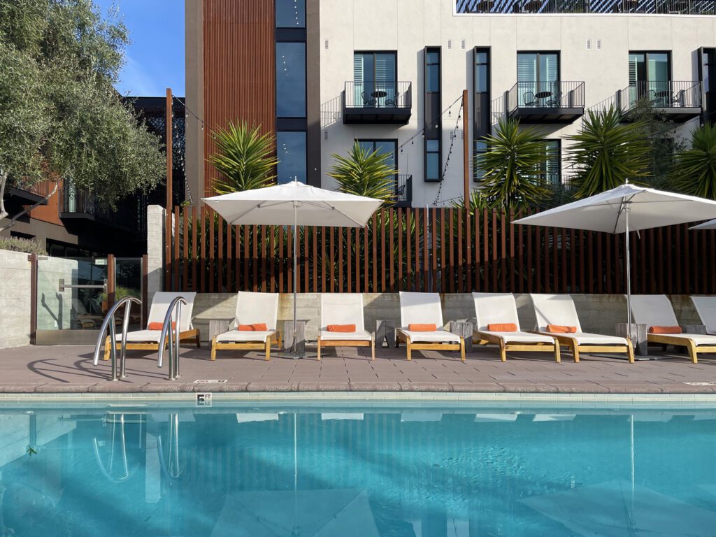 swimming pool and chaise lounge seating with shade umbrellas