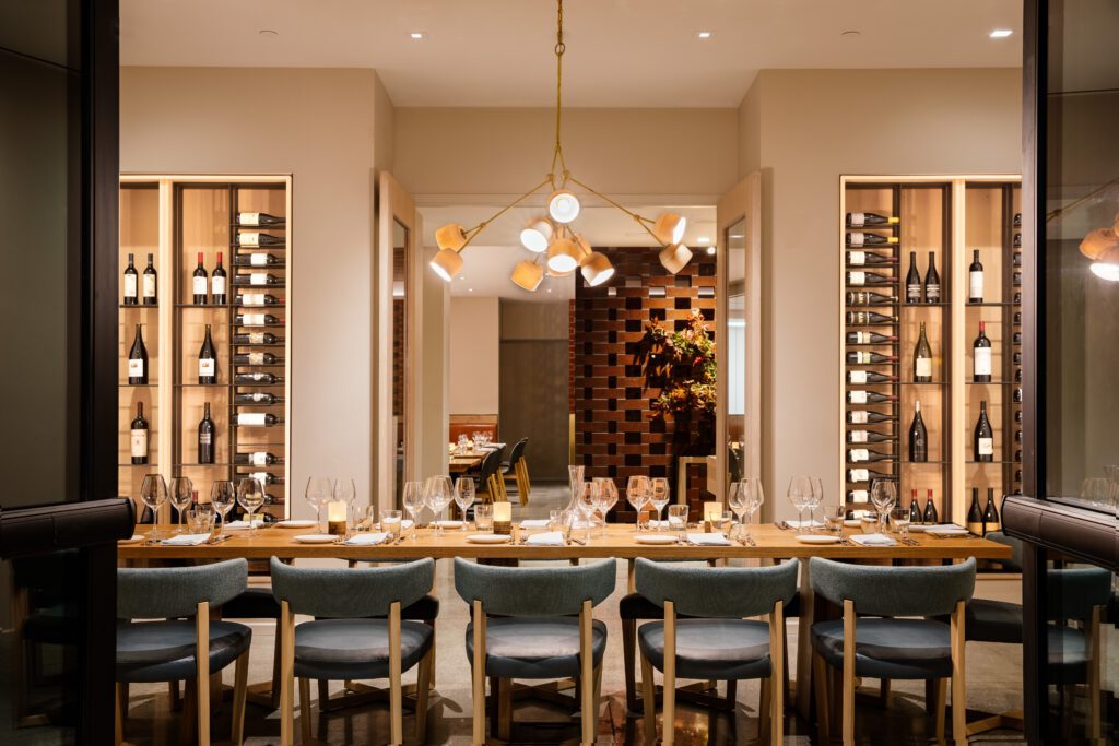 Dining table amid a wine library at Ox + Anchor