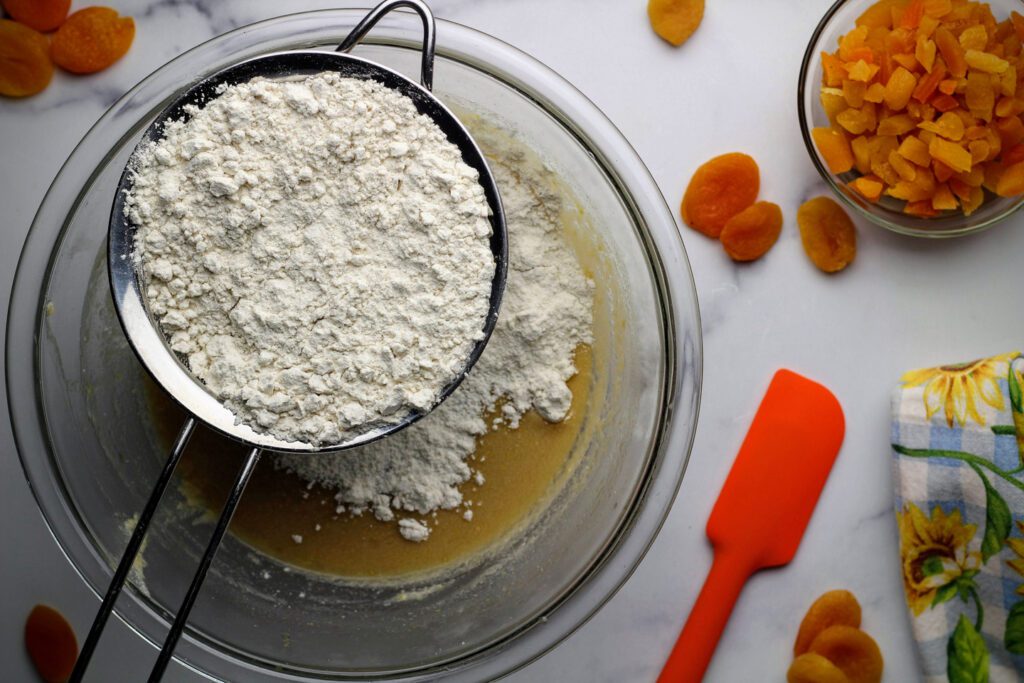 sifting flour into batter