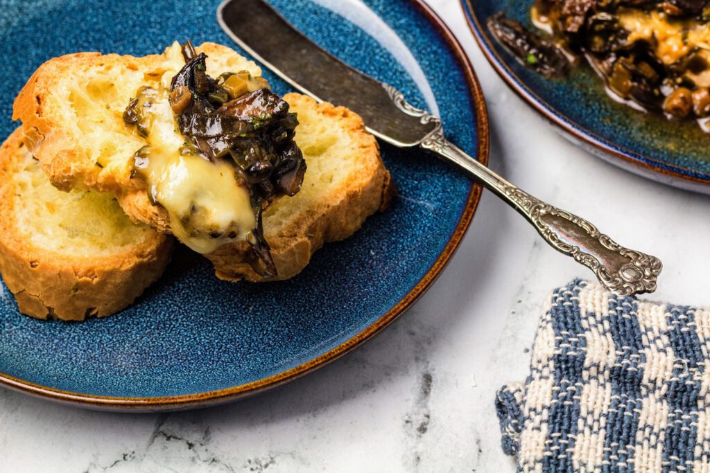 Baked brie with mushrooms on sliced baguette