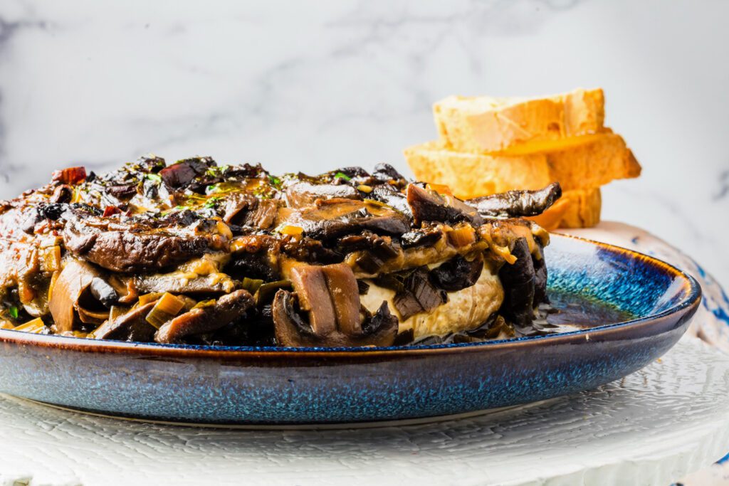 Baked brie with mushrooms and sliced baguette