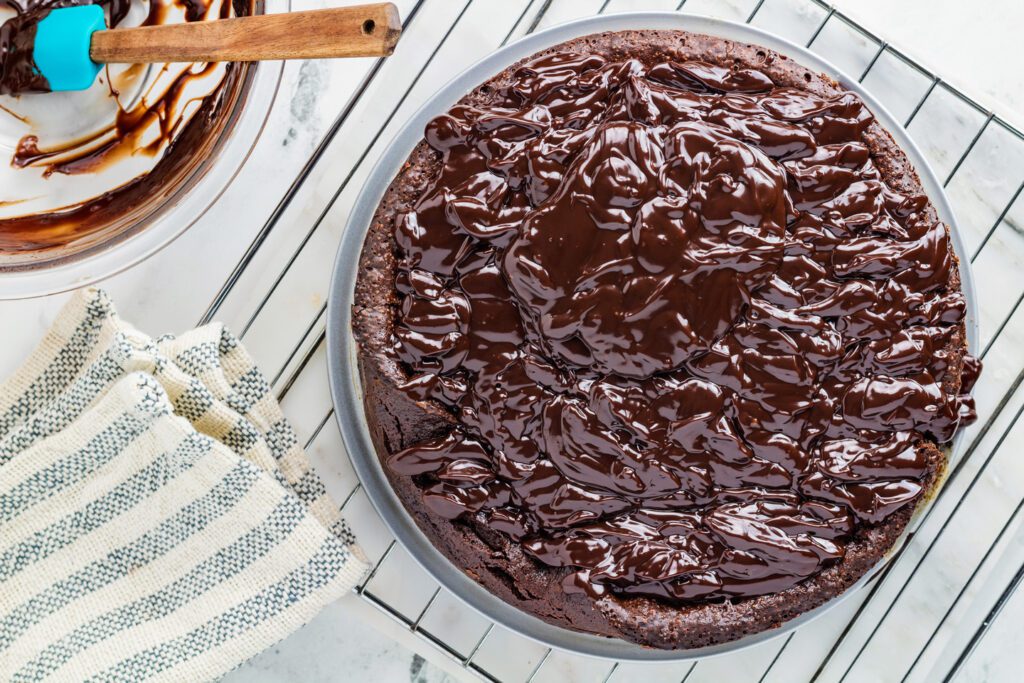 Stir hot cream into the chocolate to make a ganache, then pour over the top of the baked and cooled cake.