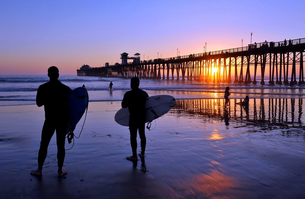 Surfers at the Oceanside Pier at sunset